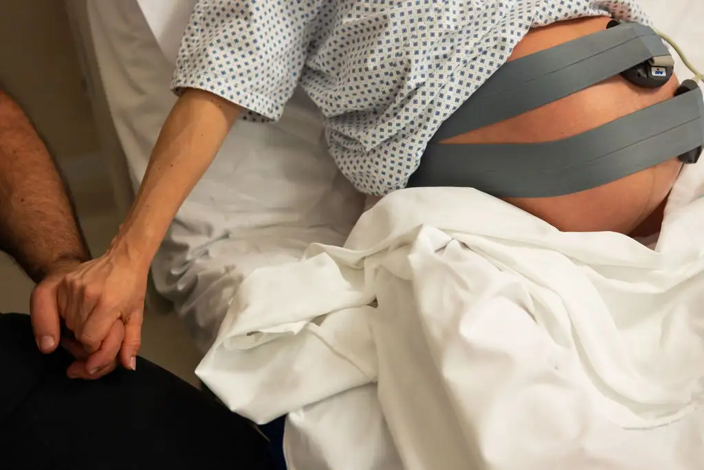 Kismama nst vizsgálaton vesz részt a párjával, közben kissé szorítva fogja a párja kezét